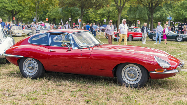 Red Jaguar E-Type parked in field