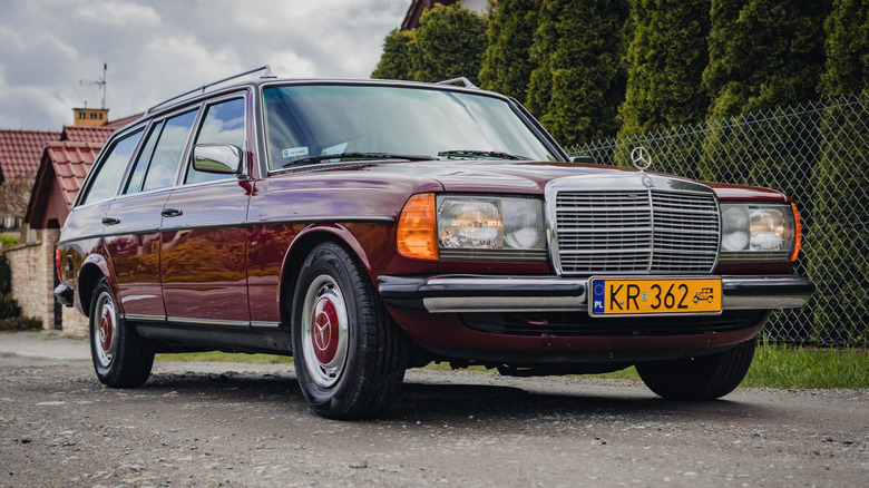 A burgundy W123 Mercedes wagon, front 3/4 view