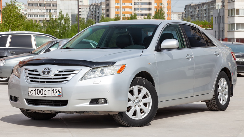 A sixth generation Toyota Camry in silver with a hood bra, front 3/4 view