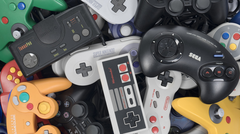 pile of retro video came console controllers