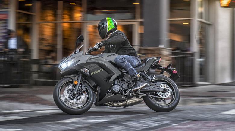 riding a gray Kawasaki Ninja motorcycle