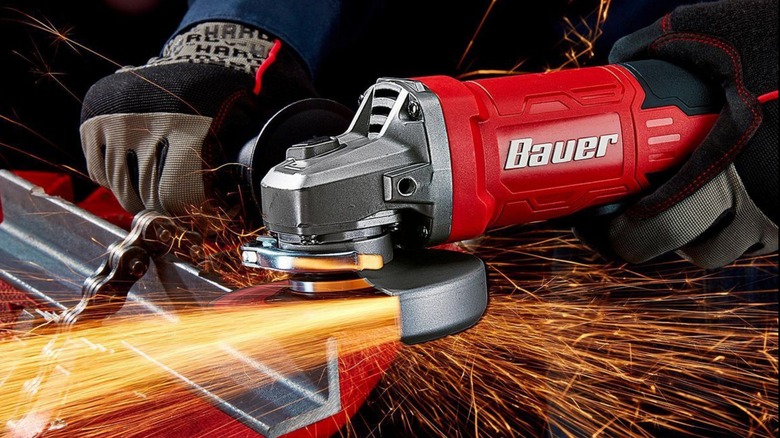 A person using a Bauer angle grinder with sparks shooting from it