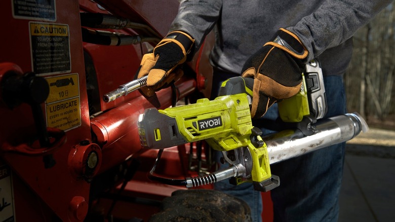 Person using Ryobi Grease Gun