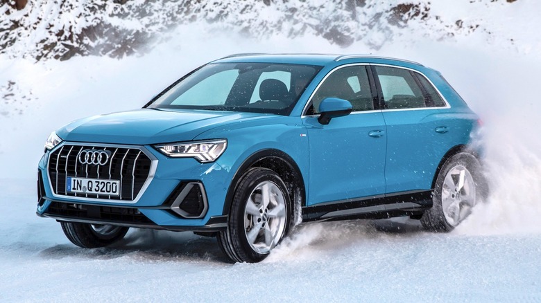 a Blue Audi Q3 driving in the snow