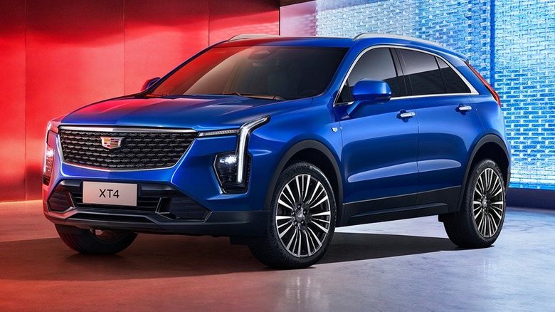 a blue Cadillac XT4 parked in a garage with red lighting