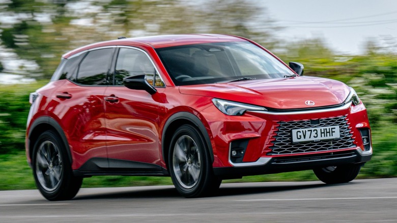 a red Lexus LBX driving on the road