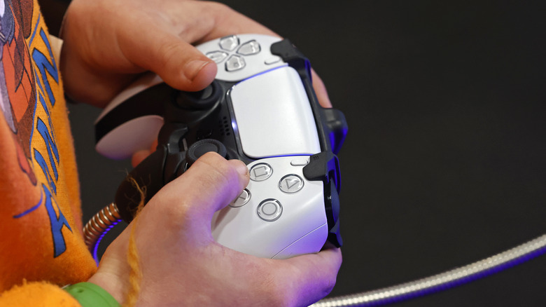 Person holding PlayStation 5 controller