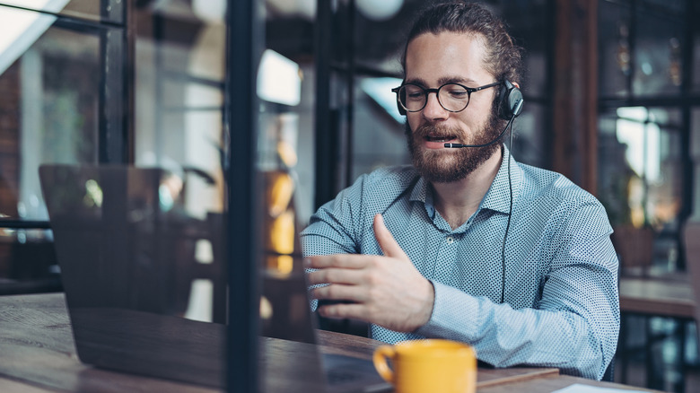 Man using laptop with headset