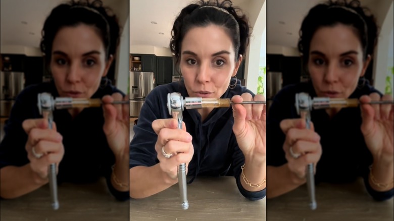 Woman fitting screwdriver into wrench socket