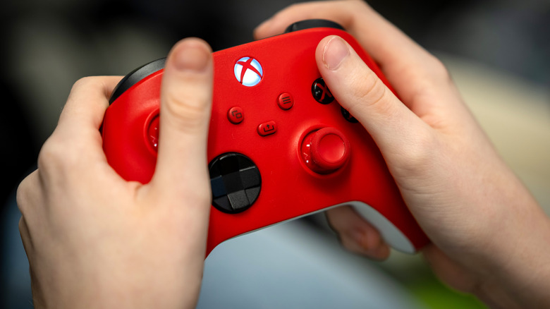 Hands holding red Xbox controller