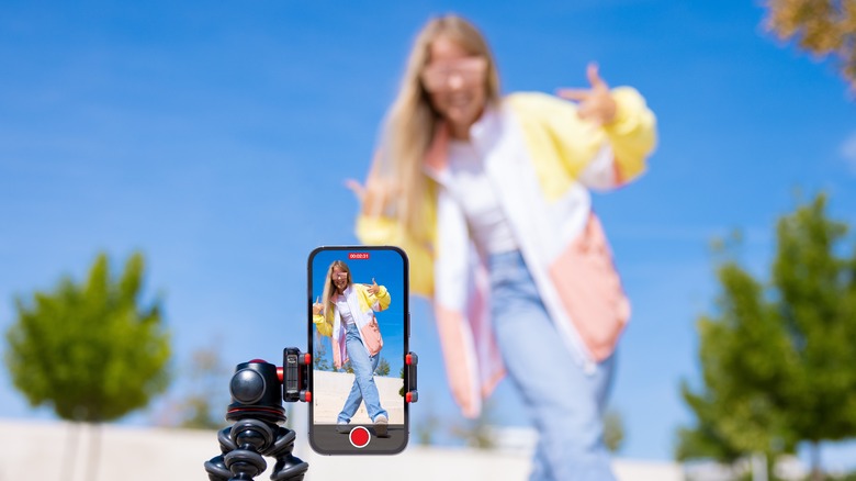 person filming video smartphone
