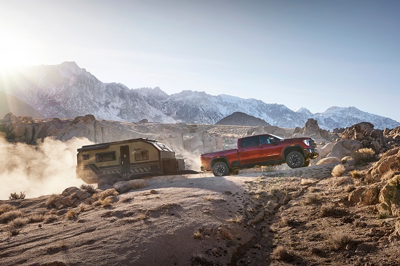 2024 GMC Sierra HD AT4X pulling a trailer through the rocky desert